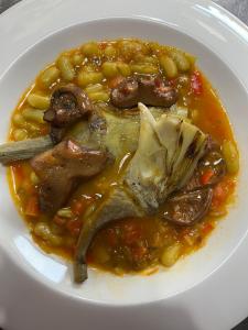 um prato de alimentos com carne, feijão e milho em Hotel Rural Quercus Tierra em Garganta de los Montes
