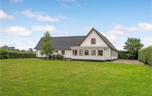 a white house with a large yard at Nice Home In Kvrndrup With 6 Bedrooms And Wifi in Kværndrup