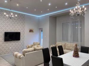 a living room with a couch and a table and chairs at Sky Apartment in Debrecen