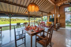 - une salle à manger avec une table et des chaises en bois dans l'établissement Villa O'Hea Ubud, à Ubud