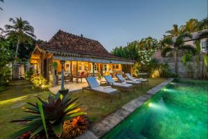 une arrière-cour avec une piscine et une maison dans l'établissement Villa O'Hea Ubud, à Ubud