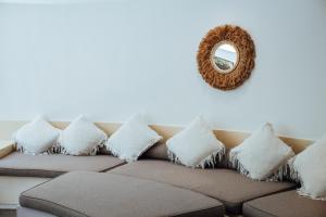 a couch with pillows and a mirror on a wall at Barrels at Bingin in Uluwatu