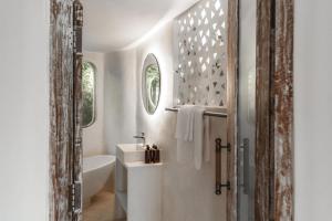 a bathroom with a tub and a sink at Blue Ocean Bingin in Uluwatu