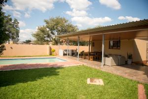 un patio trasero con piscina y una casa en Haithoms B&B Tlokweng-Gaborone, en Tlokweng