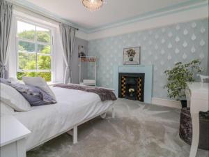 BerrynarborにあるExmoor at Your Door Walks Wine & WOW Views Hereの大きなベッドと暖炉のある寝室
