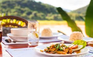 a table with plates of food on top of it at Mekong Riverview Hotel in Luang Prabang