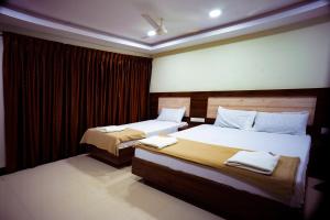 two beds in a hotel room with two bedsvisor at Hotel Sea Land in Kanyakumari