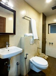 a bathroom with a sink and a toilet and a mirror at Hotel Sea Land in Kanyakumari
