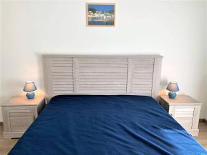 ein Schlafzimmer mit einem blauen Bett und zwei Nachttischen in der Unterkunft Appartement Quiberon, 2 pièces, 2 personnes - FR-1-478-162 in Quiberon