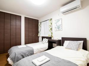 Un dormitorio con dos camas y una cómoda. en Ocean Front Maezato, en Ishigaki Island