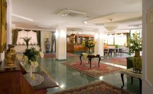 a lobby with a living room with tables and chairs at Valdenza Hotel in Campegine