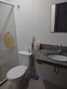 a bathroom with a toilet and a sink and a mirror at Apartamento em Cabo Frio RJ - Praia das Dunas in Cabo Frio