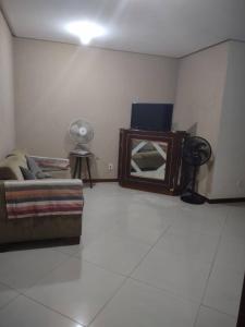 a living room with a couch and a mirror at Apartamento em Cabo Frio RJ - Praia das Dunas in Cabo Frio