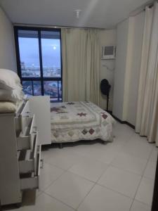 a bedroom with a bed and a large window at Apartamento em Cabo Frio RJ - Praia das Dunas in Cabo Frio