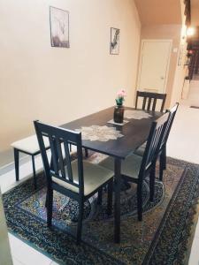 a dining room table and chairs on a rug at Laguna laguni Homestay in Sungai Petani