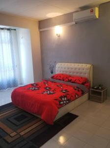 a bedroom with a red bed with a red blanket at Laguna laguni Homestay in Sungai Petani