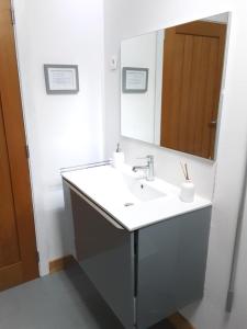uma casa de banho com um lavatório e um espelho em Maison Galloise em Auzances