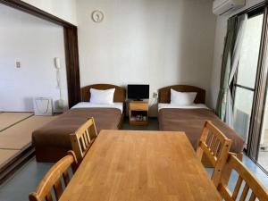 Zimmer mit 2 Betten, einem Tisch und einem TV in der Unterkunft On the Beach Lue - Vacation STAY 91567v in Sesoko + 19 Fotos