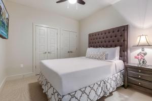 a white bedroom with a large bed and a lamp at Spacious Modern Condo near French Quarter in New Orleans