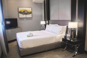 a bedroom with a bed and a television in it at Le Charmé Suites - Subic in Olongapo