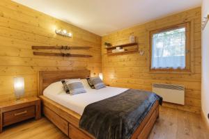 a bedroom with a bed in a wooden cabin at Appt Bec A2 - Happy Rentals in Le Tour