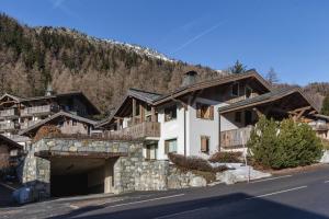 a building with a garage in front of a mountain at Appt Bec A2 - Happy Rentals in Le Tour