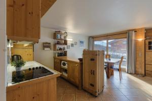 une cuisine avec des placards en bois et une table avec une table dans l'établissement Residence Bec - Happy Rentals, à Le Tour