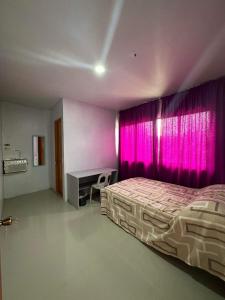 a bedroom with a bed and a pink curtain at RedDoorz at FJ Hotel Tubungan Iloilo 