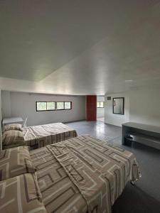 ein großes Schlafzimmer mit 2 Betten und einem Sofa in der Unterkunft RedDoorz at FJ Hotel Tubungan Iloilo 