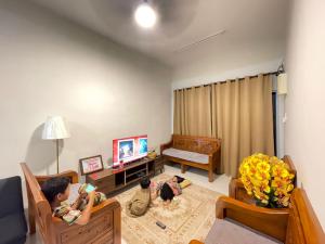 a living room with two children sitting in chairs at Homestay melaka z usaha melaka in Malacca