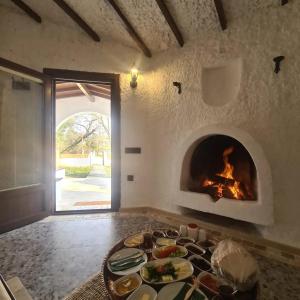 a living room with a fireplace and a table of food at Polonezköy Country Club & Accommodation in the Wildlife Park! in Beykoz