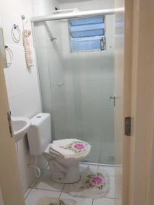y baño blanco con aseo y ducha. en Apartamento compacto, en Natal