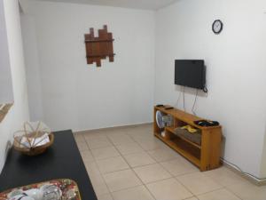 sala de estar con TV y mesa en Apartamento compacto, en Natal