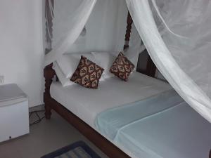 a white bed with two pillows on it at C-Lanka Guest House in Aluthgama