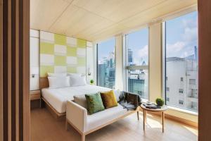 una camera con letto, divano e finestre di AKI Hong Kong - MGallery a Hong Kong Altre 37 foto