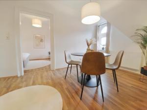 a dining room with a table and chairs at MILPAU Recklinghausen1 - Modernes und zentrales Premium-Apartment mit Queensize-Bett, Netflix, Nespresso, Smart-TV und Privatparkplatz in Recklinghausen