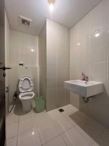 Neo Soho Apartment / Office near Central Park Mall في جاكرتا: حمام مع حوض ومرحاض