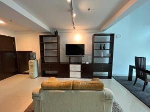 salon z kanapą i telewizorem w obiekcie Neo Soho Apartment / Office near Central Park Mall w Dżakarcie