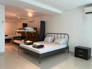 a bedroom with a bed and a desk in it at Neo Soho Apartment / Office near Central Park Mall in Jakarta