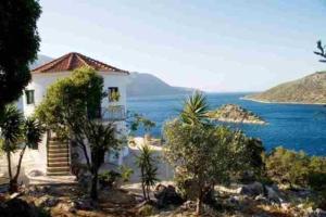 a white house with a view of the water at Razos Windmill in Vathi