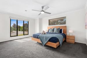 1 dormitorio con 1 cama y ventilador de techo en Summer Breeze - 10 mins to Barwon Heads & Torquay!, en Mount Duneed