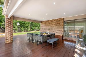 a patio with a table and chairs on a wooden floor at Summer Breeze - 10 mins to Barwon Heads & Torquay! in Mount Duneed