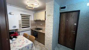 a small kitchen with a table and a dining room at La Carmen 2 ! Apartament 1 camera! in Lupeni