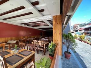 a restaurant with tables and chairs and a patio at Hotel Triple Hill in Pokhara