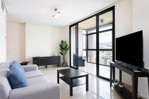 a living room with a white couch and a tv at Apartamento Jade in Santa Cruz de Tenerife