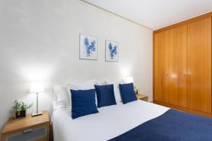 a bedroom with a large white bed with blue pillows at Apartamento Jade in Santa Cruz de Tenerife
