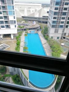 uma vista para uma piscina a partir de uma janela num edifício em I City Suite With Wifi em Shah Alam