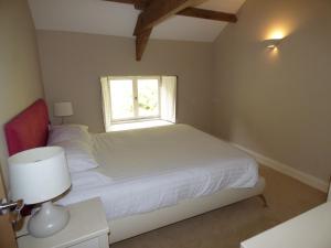 a bedroom with a white bed and a window at Clifton Cottage at Lovelady Shield in Alston