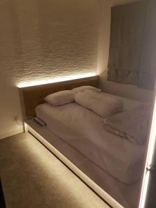 Cama pequeña en habitación con luz en Madison Park Apartment 1 Bedroom near Central Park Mall, en Yakarta
