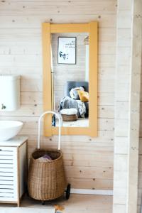 a mirror in a bathroom with a bed and a basket at Mereäärne helesinine suvemaja in Tahkuranna